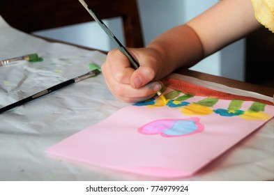 Bé tự làm thiệp chúc mừng. Một bé gái vẽ trái tim và hoa lên tấm thiệp chúc mừng tự làm để làm quà cho Ngày của Mẹ. Khái niệm chơi truyền thống. Nghệ thuật và thủ công khái niệm.