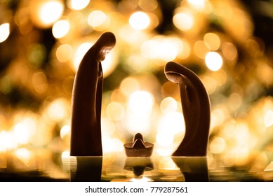 Natal. Presépio de madeira com luzes ao fundo.