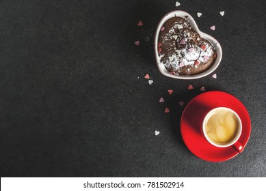 Latar belakang hari Valentine, cawan kopi merah dan kek cawan coklat atau brownie dengan gula tepung dan taburan berbentuk hati manis, latar belakang hitam, salinan paparan atas ruang