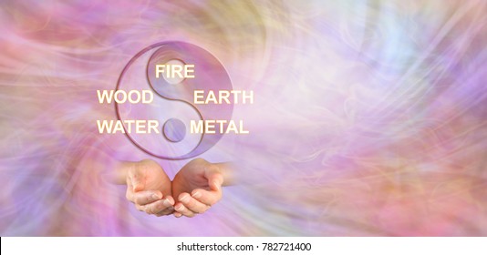 伝統的な中国医学の 5 つの要素 - カップ状の手のペアの上の陰陽のシンボルと、空気のようなエネルギーの背景に対して FIRE WOOD EARTH WATER METAL という言葉