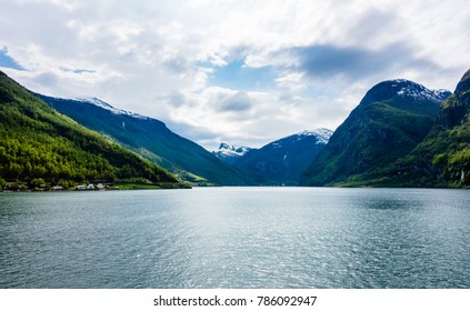 Schneebedeckte Berge und bewachsene Hänge am Sognefjord in Norwegen.