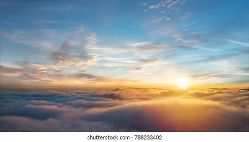 Mooie luchtfoto boven wolken met zonsondergang. Vliegtuigmening