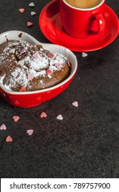 Latar belakang hari Valentine, cawan kopi merah dan kek cawan coklat atau brownie dengan gula tepung dan taburan berbentuk hati manis, latar belakang hitam, ruang salinan