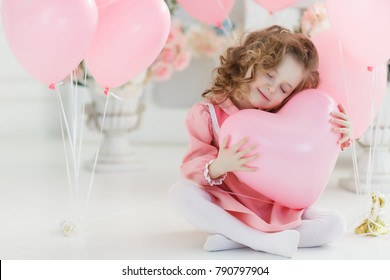 Schattig klein meisje met harten ballonnen op Valentijnsdag. familie liefde. cadeautjes op vakantie. geluk en kusjes
