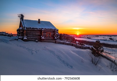 cabaña forestal y árbol en invierno. cabaña de madera en la nieve. casa de troncos en el cielo de la tarde. puesta de sol sobre el valle nevado