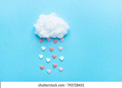 Bola de algodón Nube Lluvia Sugar Candy Sprinkle Hearts Rojo Rosa Blanco sobre fondo de cielo azul. Apliques Composición Artística Estilo Infantil. Concepto de caridad de amor de San Valentín. Tarjeta de felicitación con copia espacio