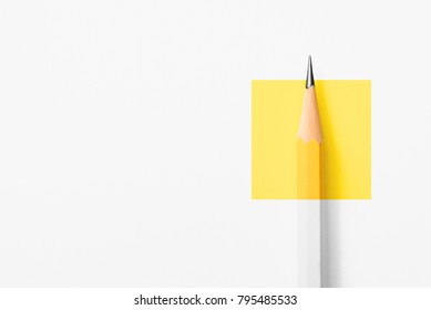 Minimalist template with copy space by top view close up macro photo of wooden yellow pencil isolated on white texture paper and combine with yellow square. Flash light made smooth shadow from pencil.