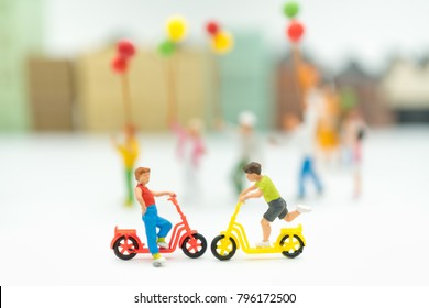 ミニチュアの人々: 教育、男の子と女の子、子供の日の概念としてコピー スペースと白い背景で遊んでいる子供たちのグループ。