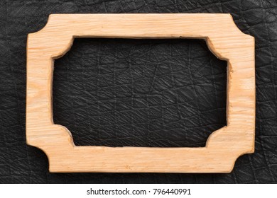 One-piece beautiful wooden frame lying on the black leather. Natural patterns, texture