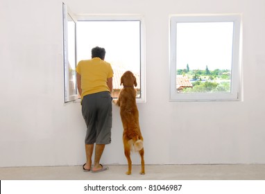 man en zijn hond kijken door raam achteraanzicht