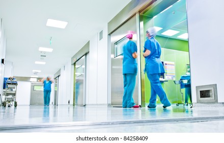 figuras borradas vestindo uniformes médicos no corredor de cirurgia do hospital