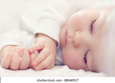 nærbillede portræt af en smuk sovende baby på hvidt