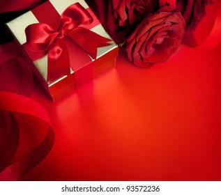 biglietto d'auguri artistico di San Valentino con rose rosse e scatola regalo isolata su sfondo rosso