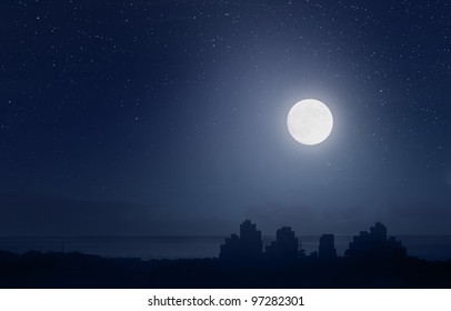 Luna llena y cielo estrellado sobre la ciudad