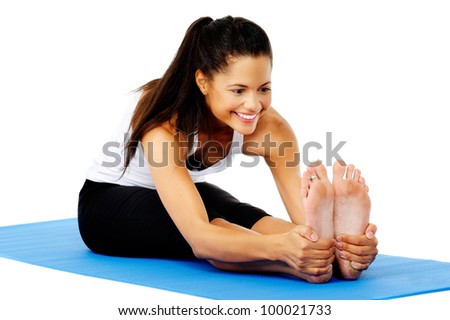 Athletic woman smiling while she stretches forward, Part of a collection of yoga poses by a fit active hispanic woman; sit-up pose