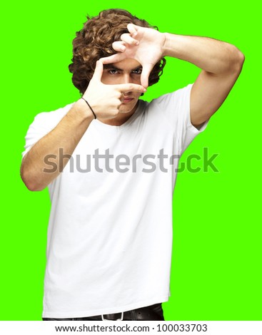 portrait of a young man gesturing a frame against a removable chroma key background