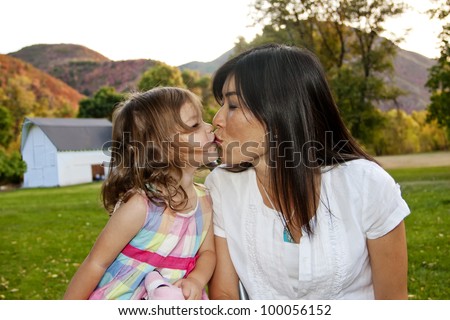 Mother kissing her cute little girl