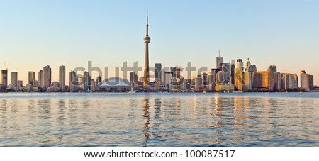 The landmark Toronto downtown view from the center island. Scenic view of the Tower illuminated by the iconic downtown skyline of skyscrapers and high rise condominiums reflecting in Lake Ontario