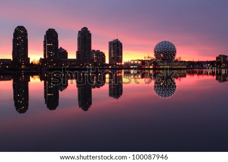 Sunrise lights up the Vancouver skyline on the edge of False Creek including condominium towers and the geodesic dome of Science World. British Columbia, Canada.