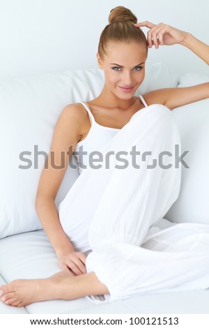 Young beautiful woman sitting on couch at her room Royalty-Free Stock Photo #100121513