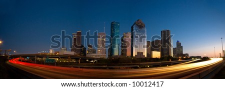 Houston skyline against blue sky after sunset surrounded by lights of highway traffic