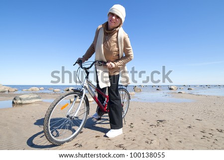 Woman and bicycle at sea.