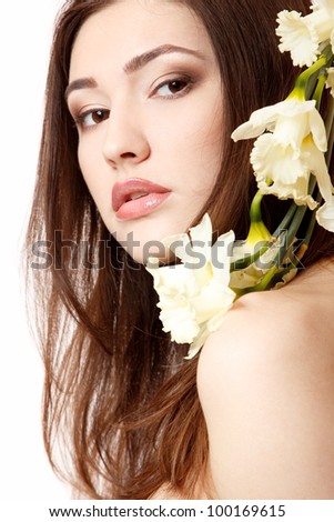 beautiful teen girl smiling and with flower narcissus and looking at camera. isolated on white