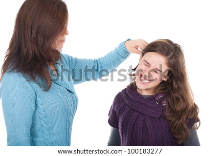 young mother pulling her daughter's ear and punishing her
