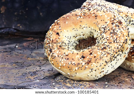 Stack of healthy bagels with sunflower meat and poppy seeds against a rustic slate background.