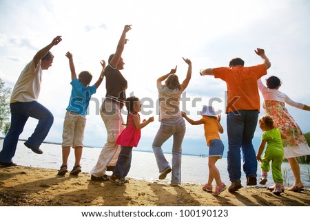 Big family from  adults and children dancing on the beach