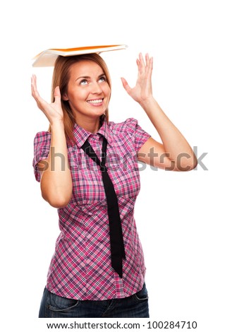 Young casual girl standing in profile smiling balancing notepad on her head on white background