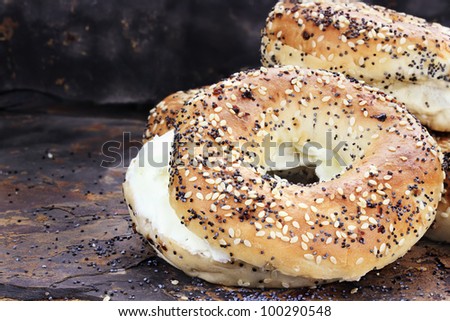 Stack of bagels and cream cheese against a rustic slate background.