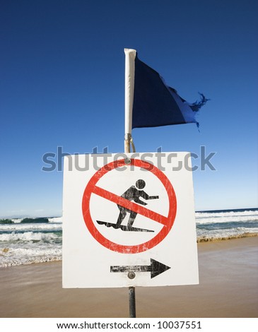 No surfing sign and flag on beach at Surfers Paradise, Australia.