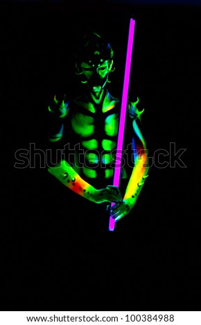 Man with fluorescent bodyart. Black background. Studio shot