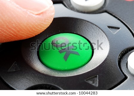 finger over remote's OK button