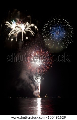 Beautiful fireworks on black sky with reflections in lake