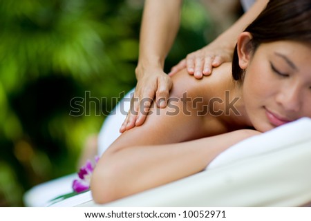 A woman getting a massage at a tropical spa Royalty-Free Stock Photo #10052971