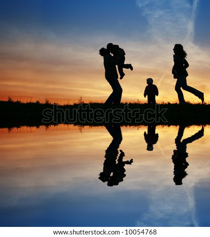 silhouette family of four and water