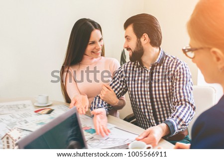Young family couple purchase rent property real estate . Agent giving consultation to man and woman. Signing contract for buying house or flat or apartments. Giving keys to couple of customers.