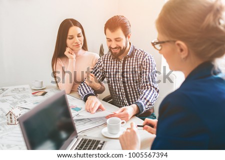 Young family couple purchase rent property real estate . Agent giving consultation to man and woman. Signing contract for buying house or flat or apartments. Discussion of size.