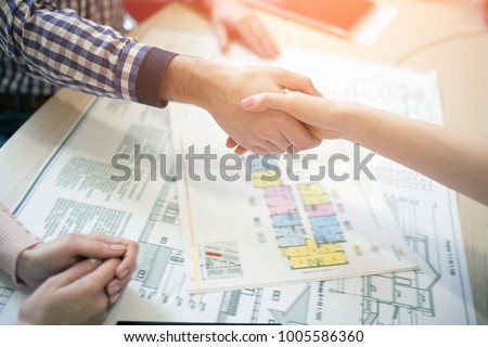 Young family couple purchase rent property real estate . Agent giving consultation to man and woman. Signing contract for buying house or flat or apartments. shaking hands . shaking hands Closeup