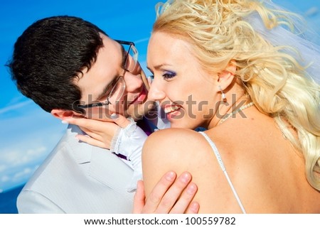 portrait of happy groom and bride on a sea coast in bright sunny day