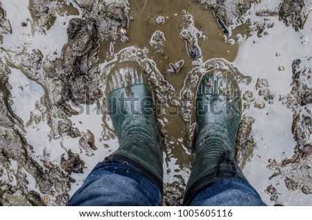 Rubber boots in the mud. Man walking in rubber boots through the mud. Georgia. The Republic of Abkhazia Royalty-Free Stock Photo #1005605116