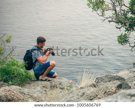 photographer tourist man looking at the screen digital SLR professional camera