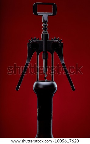 Modern metal corkscrew on red background