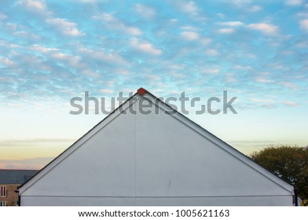 Sunset with altocumulus clouds and a white roof top.