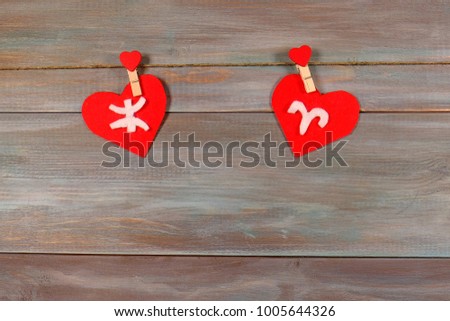 Pisces and Aries. signs of the zodiac and heart. wooden background. card. characters. unusual handwork