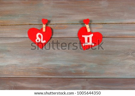 lion and twins. signs of the zodiac and heart. wooden background. card. Love. unusual handwork