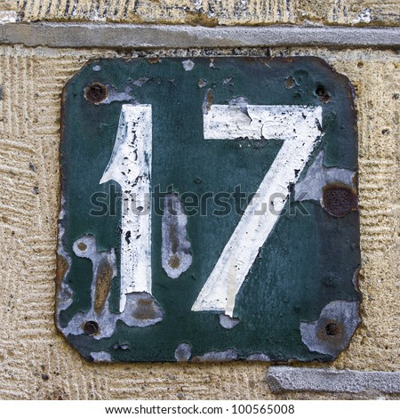 heavily weathered, hand painted house number seventeen