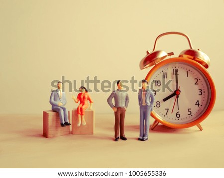 Selective focus image of miniature people  with alarm clockwork on white table background / with copy space,vintage style